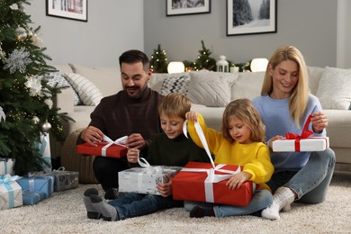 Photo of Happy family opening Christmas gifts at home