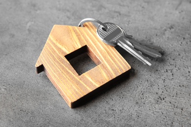 Bunch of keys and house model on grey background