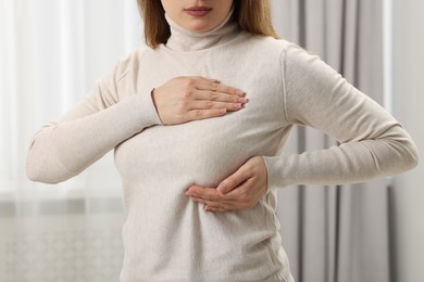 Photo of Mammology. Young woman doing breast self-examination at home, closeup