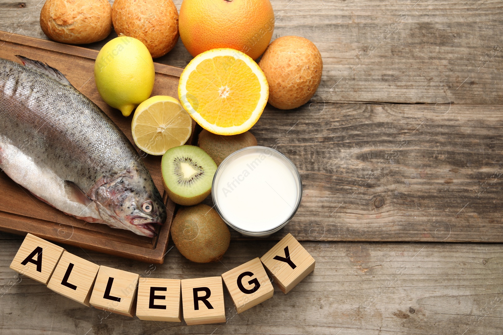 Image of Food allergy. Different fresh products and cubes on wooden table, flat lay with space for text