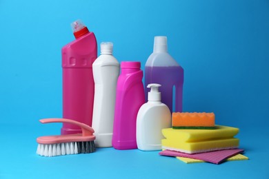 Photo of Cleaning supplies and tools on light blue background