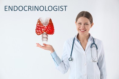Endocrinologist holding thyroid illustration on light background