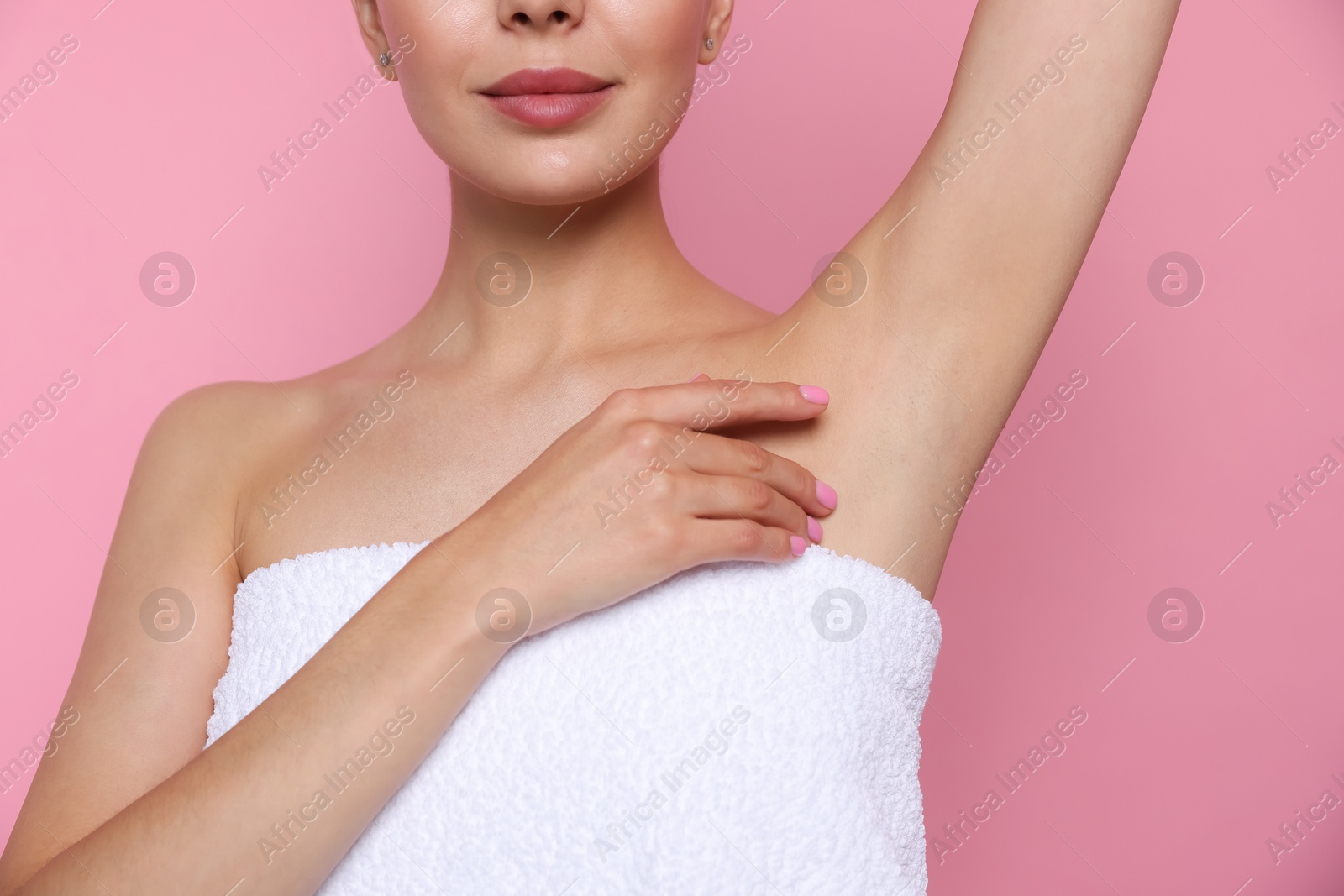 Photo of Young woman showing smooth skin after epilation on pink background, closeup