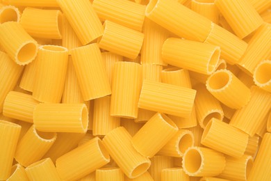 Photo of Raw rigatoni pasta as background, top view