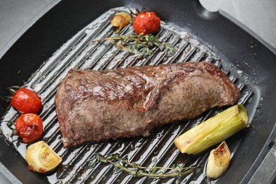Photo of Delicious grilled beef meat and vegetables in pan on table, closeup