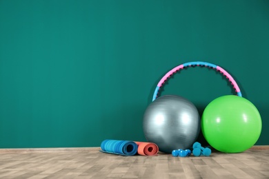 Photo of Set of fitness inventory on floor near green wall, space for text. Rehabilitation medicine