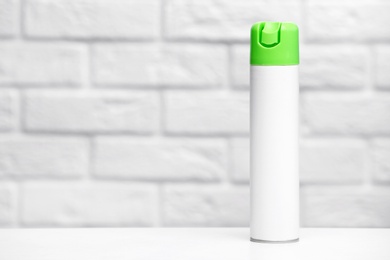 Photo of Spray air freshener on table against light background