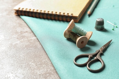 Photo of Set of tailoring accessories and fabric on table