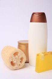 Photo of Natural loofah sponge and cosmetic products on white background