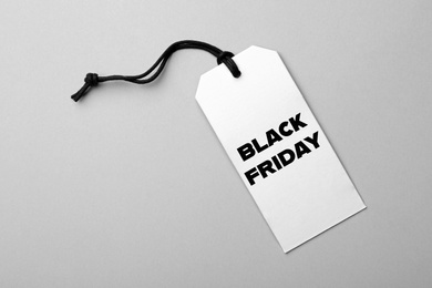 Tag with text BLACK FRIDAY on light background, top view