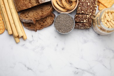 Photo of Different gluten free products on white marble table, flat lay. Space for text