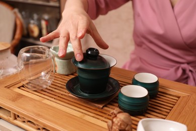 Photo of Master conducting traditional tea ceremony at table, closeup