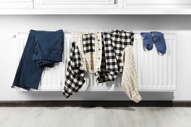 Photo of Clothes hanging on white radiator in room