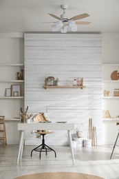 Photo of Modern studio interior with artist's workplace and art supplies