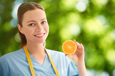 Nutritionist with orange on blurred green background