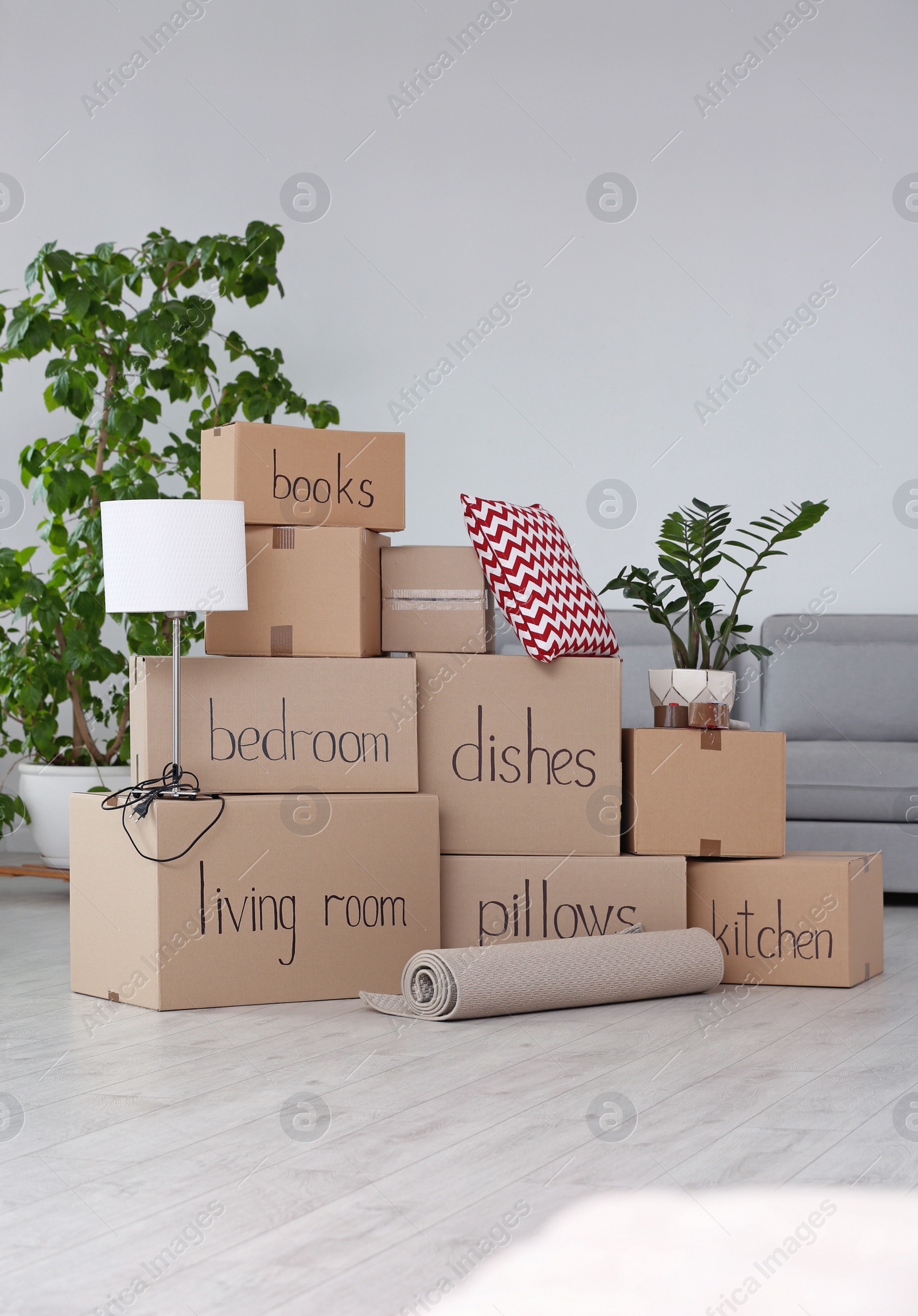 Photo of Pile of moving boxes and household stuff in living room