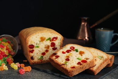 Photo of Delicious cake with candied fruits on grey table