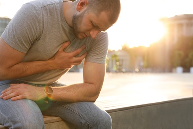 Photo of Man having heart attack on city street