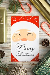 Photo of Flat lay composition with Christmas card and gift boxes on white wooden background