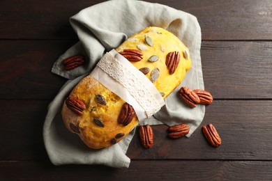 Photo of Delicious pumpkin bread with pecan nuts on wooden table, flat lay