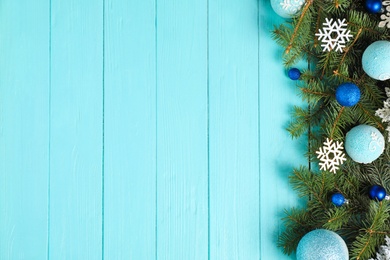 Photo of Fir branches with Christmas decoration on light blue wooden background, flat lay. Space for text