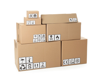 Photo of Stack of cardboard boxes with different packaging symbols on white background. Parcel delivery