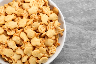 Photo of Delicious goldfish crackers in bowl on table, top view