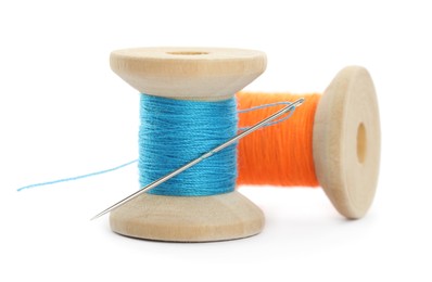 Photo of Colorful sewing threads with needle on white background