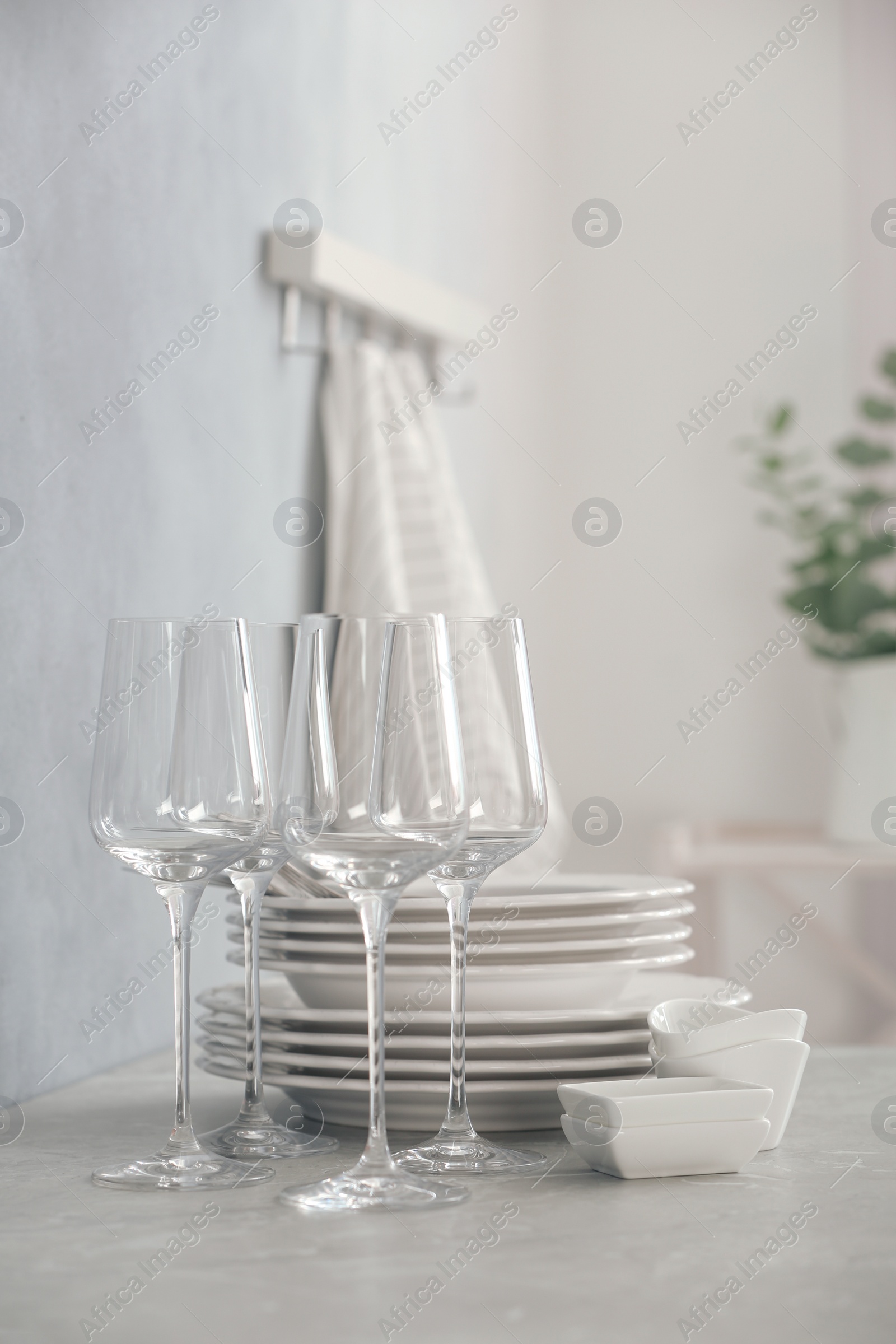 Photo of Set of clean dishware and wineglasses on grey table indoors. Space for text