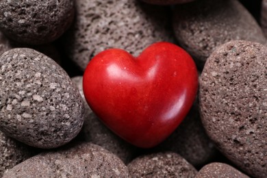 Photo of One red decorative heart on stones, above view