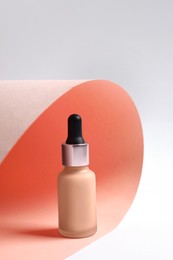 Photo of Bottle of skin foundation on color background. Makeup product