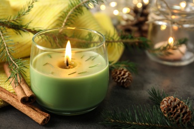 Photo of Composition with burning candle and pinecones on black table, space for text