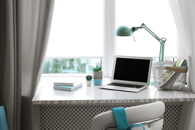 Photo of Comfortable workplace with laptop on window sill at home