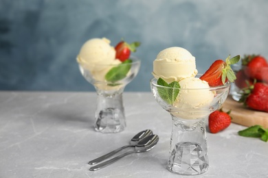 Photo of Delicious vanilla ice cream with strawberry served on table. Space for text