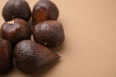 Photo of Delicious salak fruits on pale brown background, closeup. Space for text