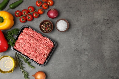 Photo of Flat lay composition with minced meat and space for text on grey background