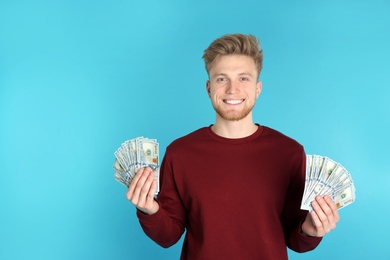 Photo of Young man with money on color background. Space for text