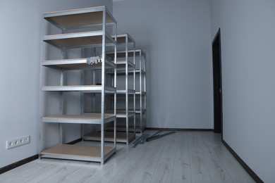 Photo of Office room with white walls and metal storage shelves