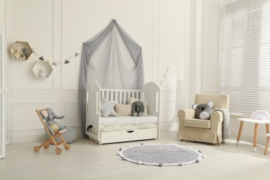Photo of Cozy baby room interior with crib and toys