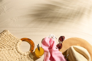 Photo of Different beach accessories and glass of cocktail on sand, flat lay. Space for text