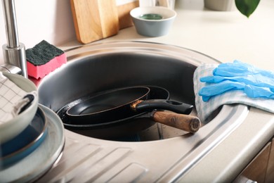 Photo of Sink with dirty frying pans in kitchen