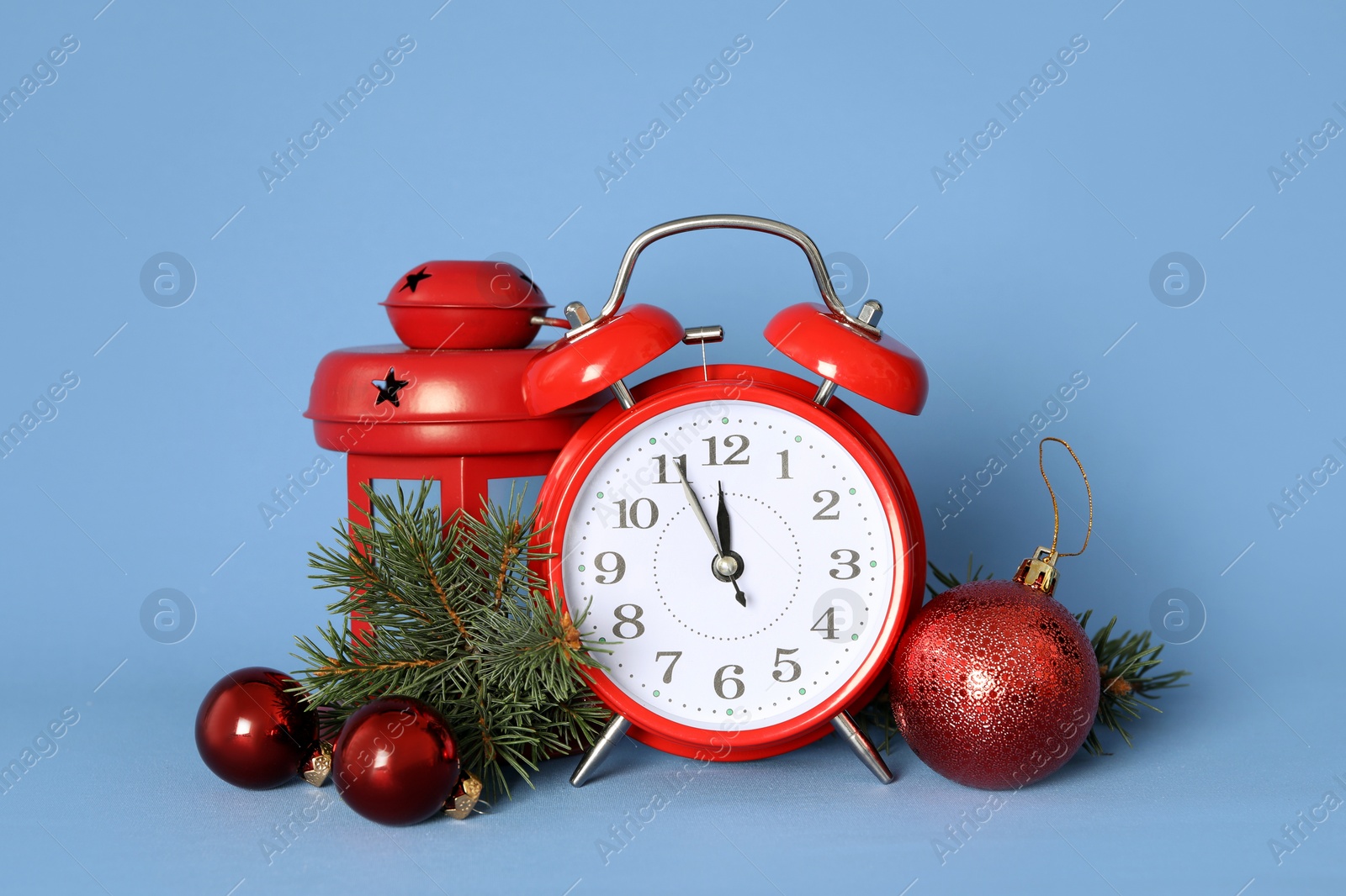 Photo of Alarm clock and festive decor on blue background. New Year countdown