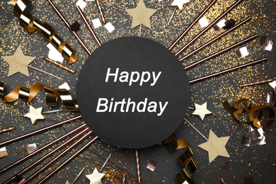 Photo of Flat lay composition with party decor and text Happy Birthday on black background