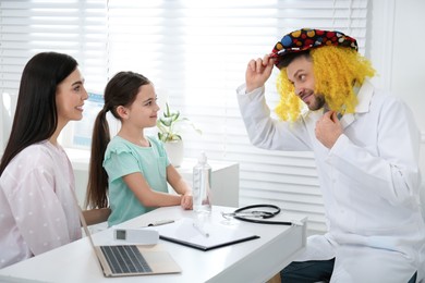 Photo of Mother with daughter visiting funny pediatrician in hospital