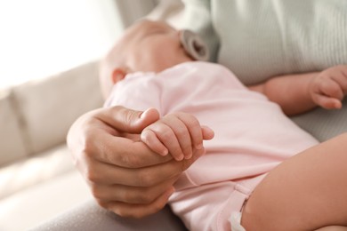 Photo of Mother holding her cute sleeping baby at home, closeup
