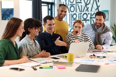 Photo of Team of employees working together at table in office. Startup project