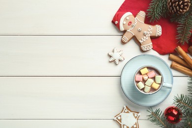 Photo of Delicious hot chocolate with marshmallows near cookies and Christmas decor on white wooden table, flat lay. Space for text