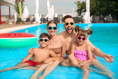 Photo of Happy family in swimming pool on sunny day