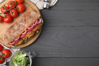 Photo of Delicious sandwich with schnitzel on grey wooden table, flat lay. Space for text