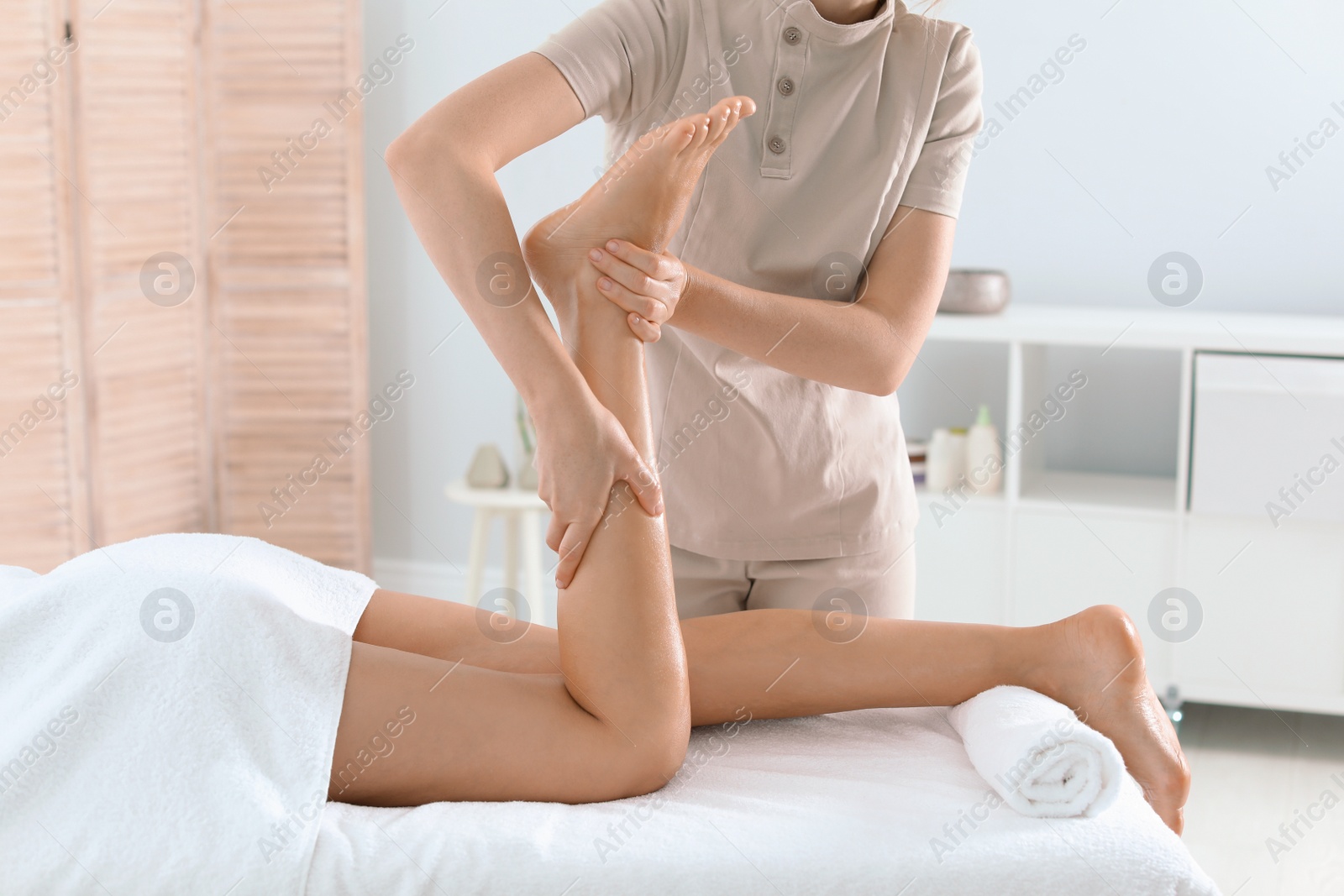 Woman receiving leg massage in wellness center Photo of Woman receiving leg massage in wellness center